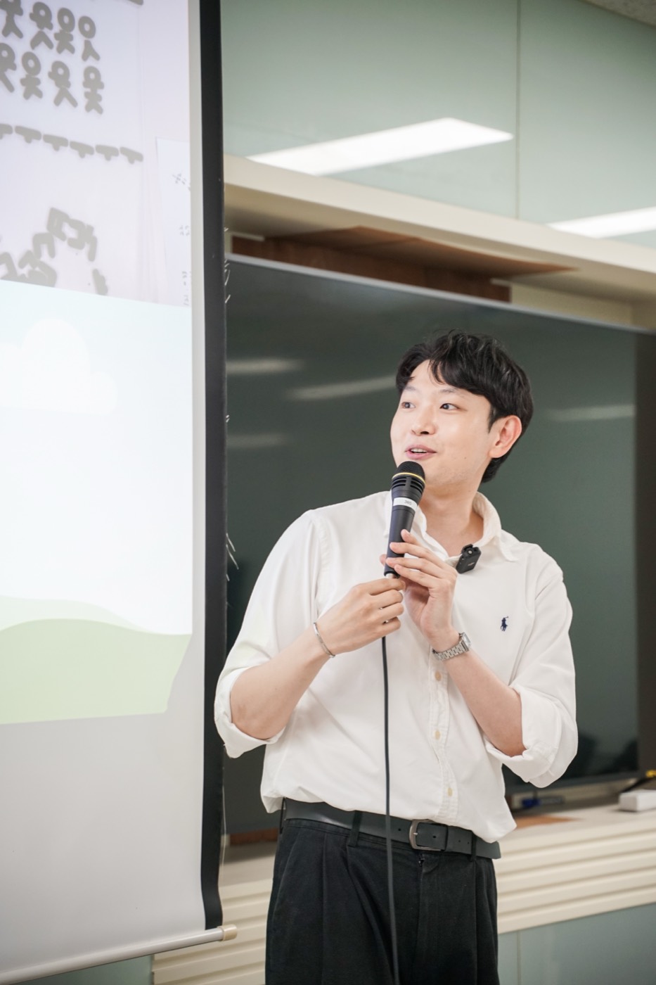 KONNECT 호스트가 마이크를 들고 모임을 진행하는 모습